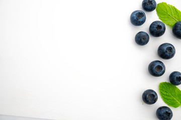 organic blueberries and leaves in isolated white background, flavor concept 