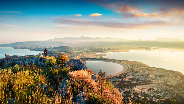 Photographer take a picture of spring view of the Voidokilia beach from Navarino Castle. Great sunrise on the Ionian Sea, Pylos town location, Peloponnese, Greece, Europe. 