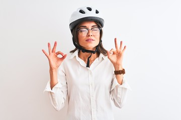 Beautiful businesswoman wearing glasses and bike helmet over isolated white background relax and smiling with eyes closed doing meditation gesture with fingers. Yoga concept.