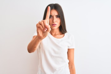 Obraz na płótnie Canvas Young beautiful woman wearing casual t-shirt standing over isolated white background Pointing with finger up and angry expression, showing no gesture