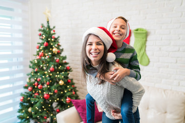 Playful Mother And Son Enjoying Christmas At Home