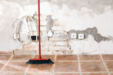 Unfinished room reconstruction. Home repair, improvement. Work in progress. Red broom against white...
