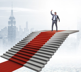 Young businessman climbing stairs and red carpet