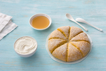 Freshly baked carrot scones with cream and honey on light blue background. delicious homemade cakes. copy space