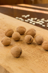 Walnuts on a light board and pumpkin seeds on a dark table. The rays of the sun on the table. Low calorie diet concept