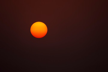 yellow and red perfectly round glowing sun against a dark background
