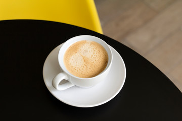 Coffee in white cup on black table at the kitchen or cafe