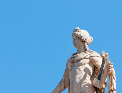 Apollo statue, the ancient greek god of music and poetry, blue sky as space for text