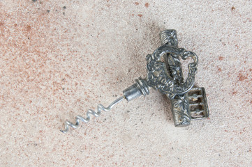 Antique corkscrew on concrete background