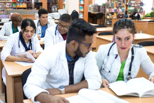 a multinational group of medical students, sitting at the table, studying medical literature