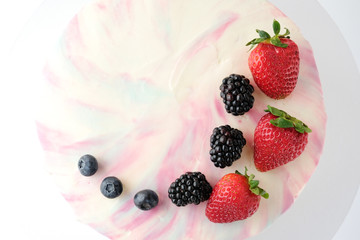 Birthday cake with strawberries, blueberries and blackberry on white background. Picture for a menu or a confectionery catalog.