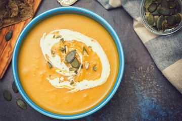 Homemade pumpkin soup served with cream and pumpkin seeds