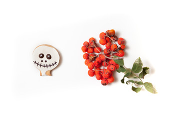 Cookies mask for Halloween and rowan branch on white background