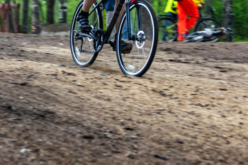 Cyclist rushing along a forest path from sawdust