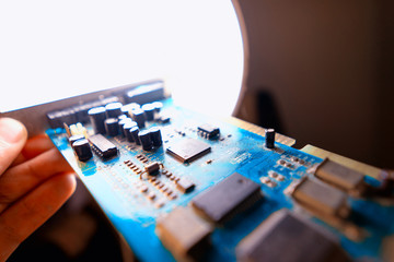 blue electronic circuit board on hand