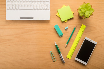 Office table with keyboard, phone, pen, pencil, ruler and flower