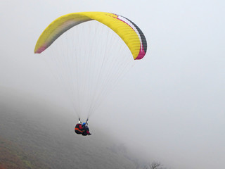 Tandem Paraglider flying yellow wing