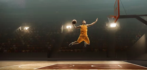 Gordijnen Professionele basketbalspeler op sportarena in actie met de bal. Slam dunk © TandemBranding