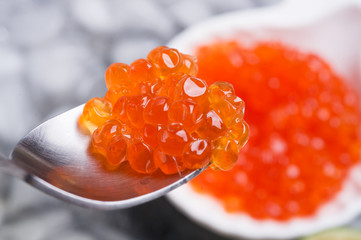  fresh red  salmon caviar in spoon. served around ice. macro shot.  Protein luxury delicacy  healthy food