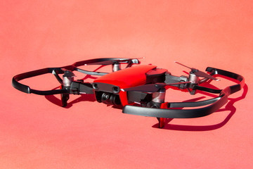 Drone quadcopter with blade protection, with camcorder on red background