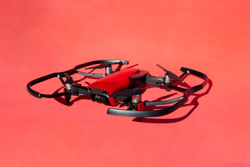 Drone quadcopter with blade protection, with camcorder on red background