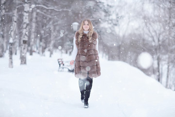 Fototapeta na wymiar walk in a winter park christmas girl / beautiful model posing in the winter season walk city park