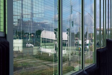 Fototapeta na wymiar Acoustic road screen (sound absorbing panel) next to the expressway. Moving cars visible through the glass.