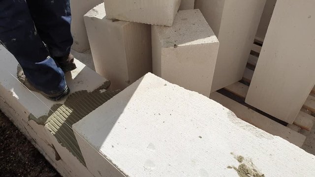 The builder is building a house of blocks. Building construction.