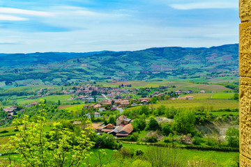 Obraz premium Vineyards and countryside in Beaujolais, with the village Saint-Laurent-d-Oingt