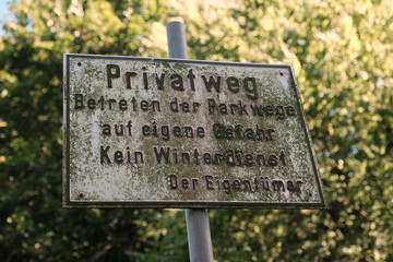 Altes Schild am Privatweg durch den Park an der Alten Müllerburg im Sommer bei blauem Himmel und...