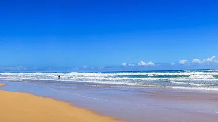 Papier peint photo Vagues de l'océan Beautiful wide panoramic view of the ocean waves rolling towards tropical sandy beach and a silhouette of a man standing in the water. Gold Coast, Queensland, Australia.   © SeaRain