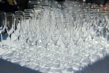 A row of empty champagne glasses on table. Banquet setting