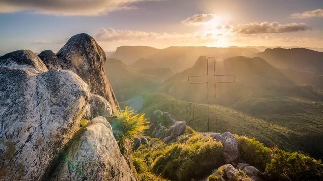 Prayer at the cross religion at sunrise mountain top in Jasper Canada