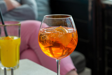 Aperol spritz and a orange juice standing on the table