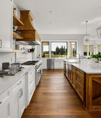 Kitchen in New Luxury Home with White Counters and Rich Dark Cabinets and Hardwood Floor