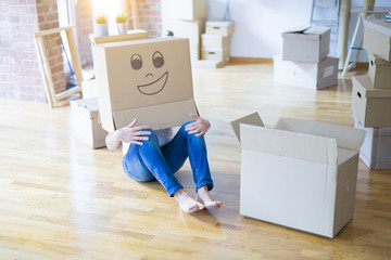 Man wearing funny cardboard box with happy face, moving to a new house, crazy and creative concept