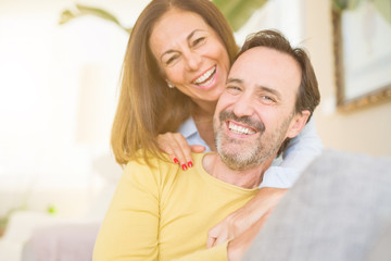 Middle age romantic couple sitting on the sofa at home
