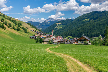 Fototapeta na wymiar Picturesque path leading to a small beautiful alpine town Longiaru (Campill) Longiarù - Val Pusteria, Alto Adige, Italy