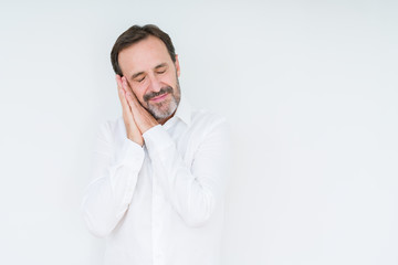 Elegant senior man over isolated background sleeping tired dreaming and posing with hands together while smiling with closed eyes.
