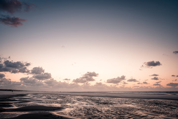 Obraz premium Beach landscape, sunset at the beach, beautiful blue cloudy sky, orange sky, contrast, light, shadow, idyllic, sand winds, Dutch north sea, coast, Wadden island, Friesland, the Netherlands