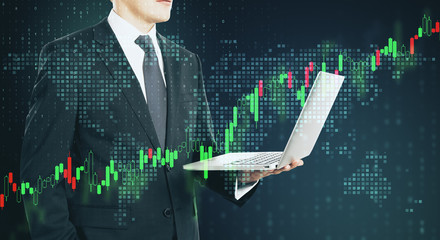 Businessman traider with laptop and digital screen with forex graphs and pixel world map.Double...