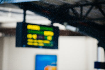 Rain water drops in front of defocused arrival departure board in Belgium Ostend train station