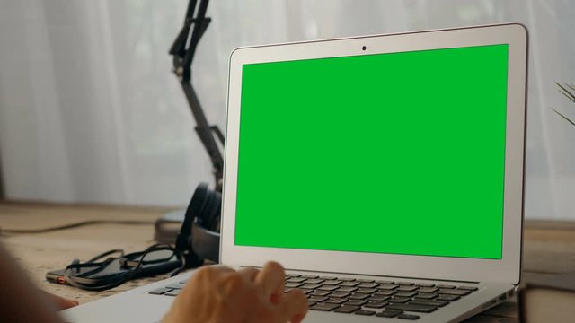 4K: Woman working at home on with laptop green screen