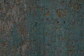 wall of a metal fence with rusty spots under a wash-out layer of blue paint