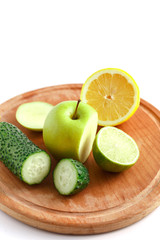 Naklejka na ściany i meble Sliced green apple, cucumber and lime on a wooden cutting board.