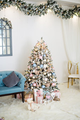 New year greeting card. Elegant interior with snow-covered, fashionable Christmas trees with boxes of gifts, decorated with garlands, wreaths, glass toys. Shabby chic style. Copy space. Modern room