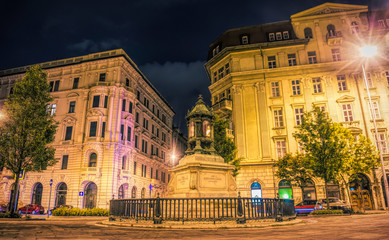 Fototapeta na wymiar Budapest / Hungary - August 30 2019: Ancient beautiful gothic building and street car traffic on the night streets of Budapest, Hungary. Tourist historical quarter of the capital of Hungary