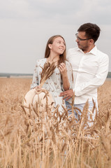 Young couple in a wheat field on a sunny day