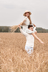 Young couple in a wheat field on a sunny day