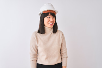 Young beautiful Chinese architect woman wearing helmet over isolated white background looking away to side with smile on face, natural expression. Laughing confident.